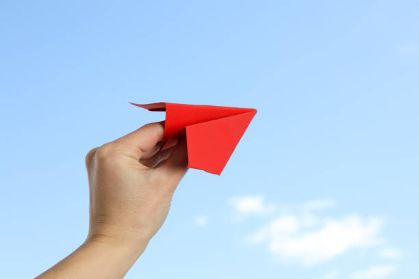 istock Female hand with paper plane on sky background 2148820534