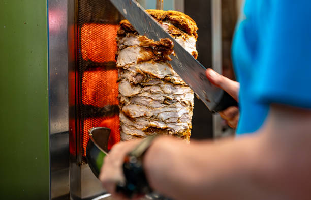 istock Man cutting juicy meat on shawarma spit. 2148820615