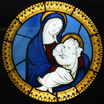 A victorian stained glass image from a church in Wales.It depicts Jesus with children, recalling when He said to His Apostles,\
