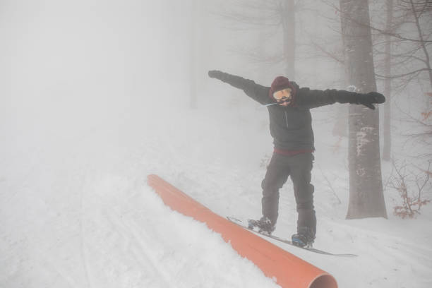 young snowboarder riding on jibbing handrail