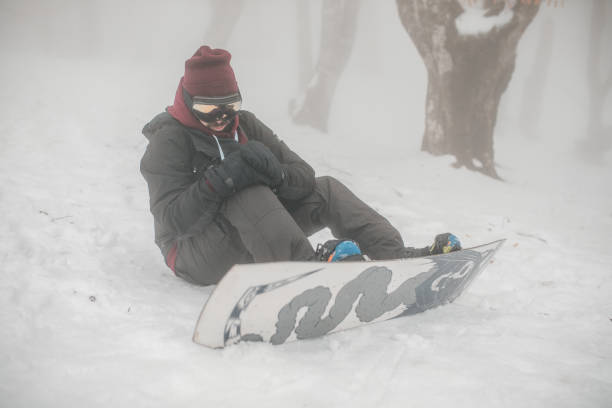istock Man sitting on snow after falling from snowboard in the mountain 2148825287