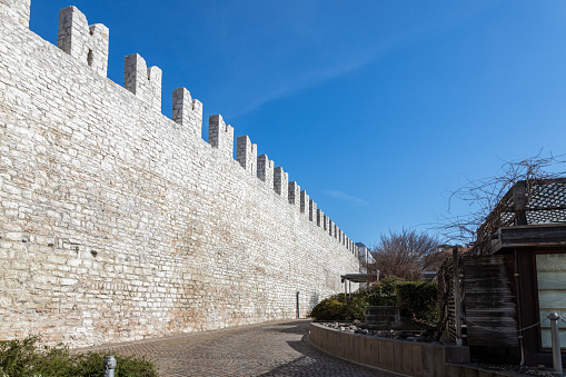 View of medieval city walls in Trento city centre at Piazza Fiera (Fair Square) in a sunny day; Trentino-Alto Adige, Italy