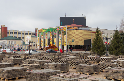Uralsk, Oral, Kazakhstan (Qazaqstan), 26.03.2020 - Deposited paving stones on wooden pallets on Abay Square in the city of Uralsk. Disassembled paving stones stacked on pallets. Kazdrama theater in Uralsk.