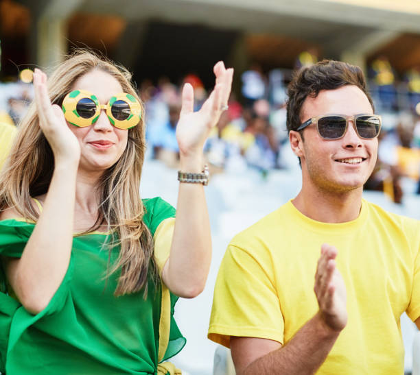 Sports fans: joyful soccer supporters react to match action in a stadium