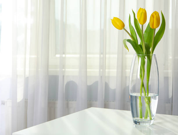 istock Tulips in a vase on the table near the window 2148827639