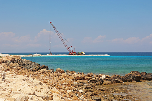 Construction work is underway on the coast of the sea.