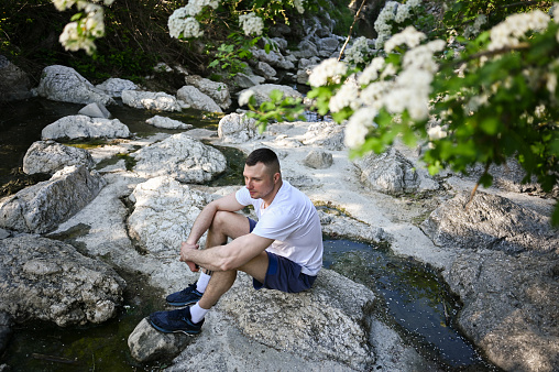 Young man relaxing on a river bank.