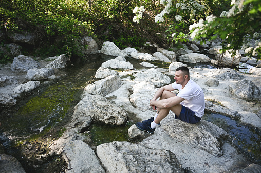 Man relaxing in a mountain river bank.