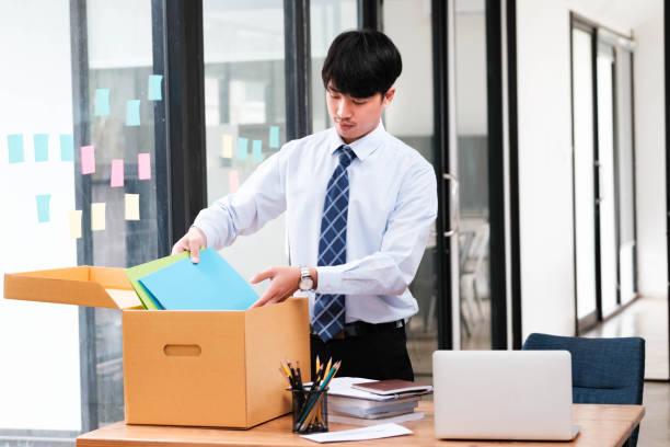 istock A man in a suit is opening a cardboard box on a desk 2148831669