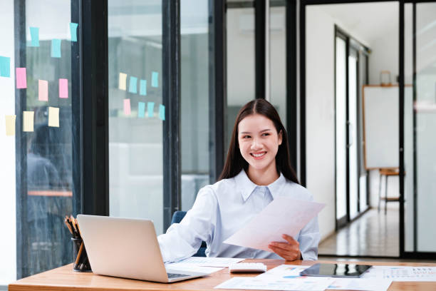 istock Smiling Businesswoman with Documents at Office Desk 2148831718
