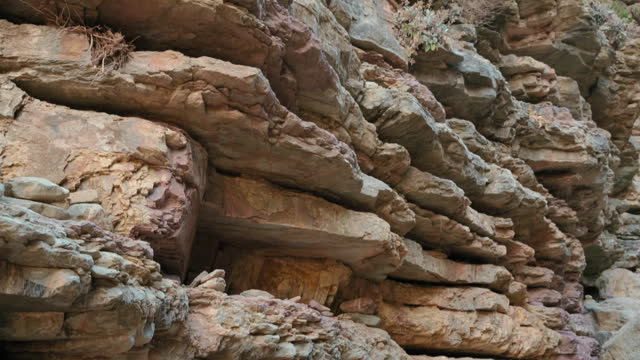 A rocky cliff with a brown and red color