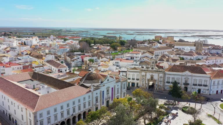 Traditional Portuguese town of Faro on the oceanfront with old architecture, filmed by drone. Arco de villa and largo de se. Ria formosa in the background.