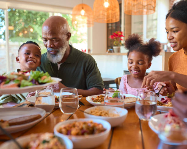 istock Multi-Generation Family Around Table Serving And Eating Meal At Home Together 2148833423