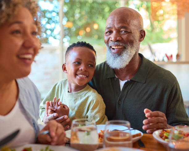istock Multi-Generation Family Around Table Serving And Eating Meal At Home Together 2148833457