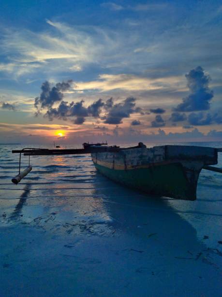 istock Blue boat before sunset at sea shore 2148834145
