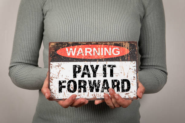 istock Pay It Forward. Warning sign with text woman in hand 2148834331
