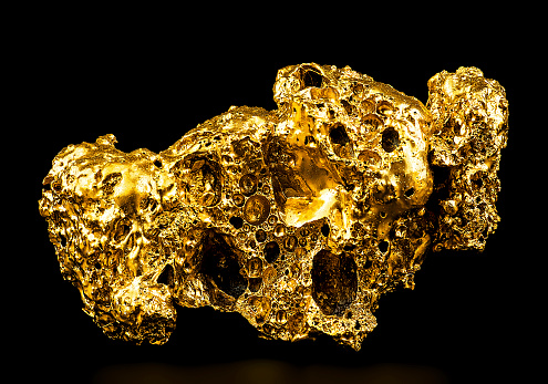 Pure gold from the mine on a black background. Gold ore as finance and business concept.