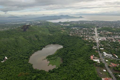 Green volcano crater next to Managua city in Central america aerial drone view