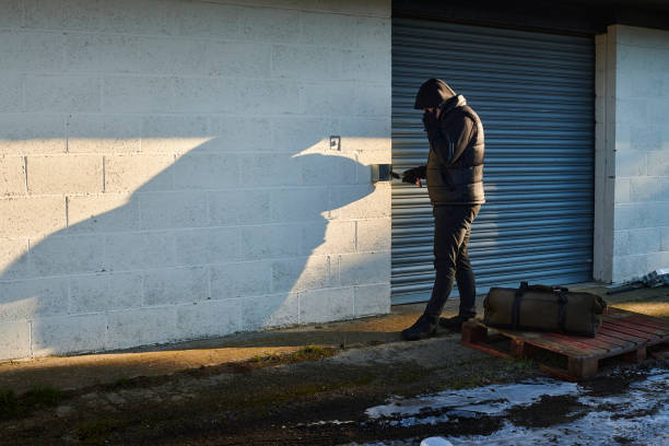 suspicious man at storage facility - achterdocht fotos stockfoto's en -beelden