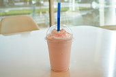 Picture of ready-to-drink milk shake mixed with strawberries on the dining table.