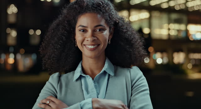 Business woman, city and smile at night in arms crossed for travel, commute and legal career or job. Excited face or portrait of young worker or African lawyer outdoor in confidence and bokeh lights