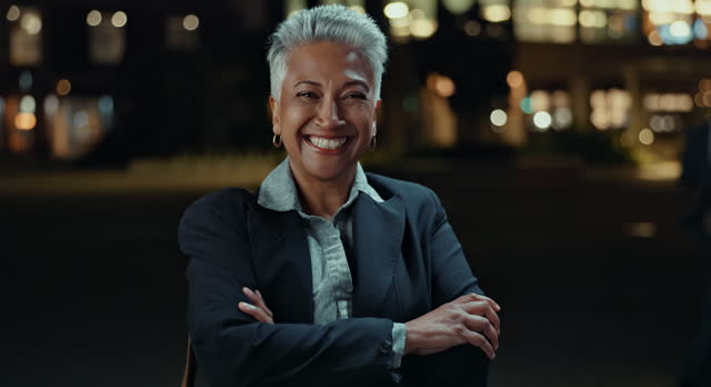 Business woman, city and happy at night in arms crossed for travel, commute and legal career or job. Excited face or portrait of senior person, boss or Indian lawyer with confidence and bokeh lights