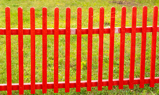 Red wooden fence in nature. Background.