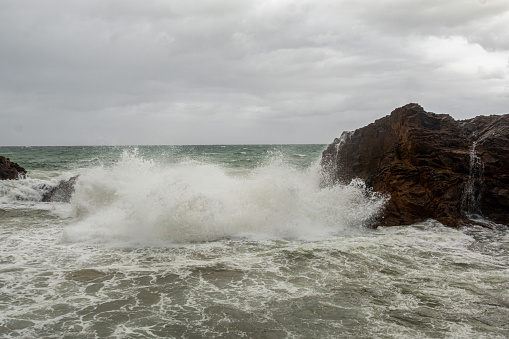 Waves hitting a sea rock with great force. winter storm.