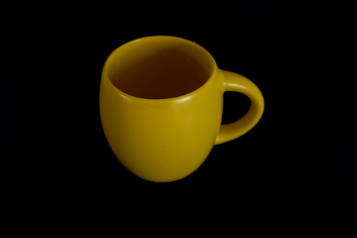 a large yellow cup on a black background