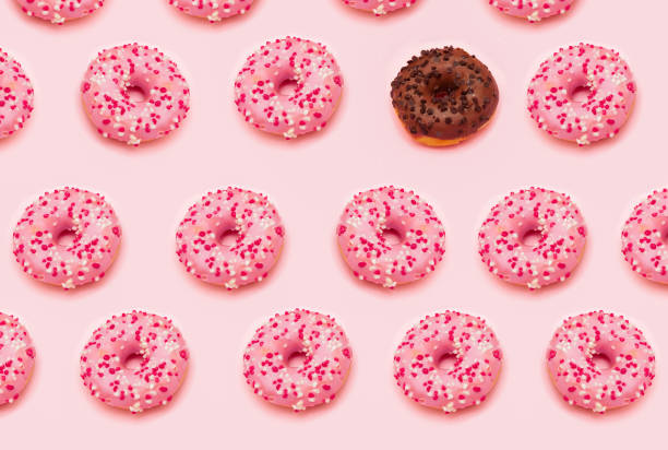 istock Pattern of pink doughnuts and a single chocolate doughnut 2148839826