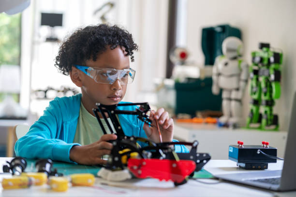 istock A talented African boy is engrossed in designing prototype robots on his computer during a school break. Child's focus and enthusiasm for robotics and technology, highlighting his engagement in e-learning and STEM topics. 2148839999