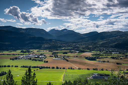 High angle view of agricultural rural villages Sylte and Skei in Surnadal, Western Norway, with the Surnadalsfjord mountains with some snow left in the background