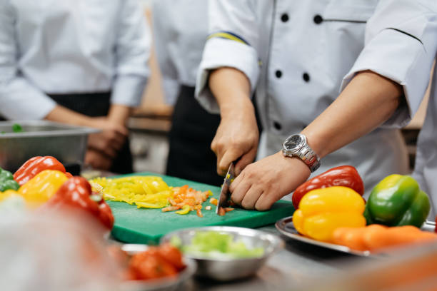 istock Chefs in uniform cutting ingredients while cooking in restaurant kitchen 2148840410