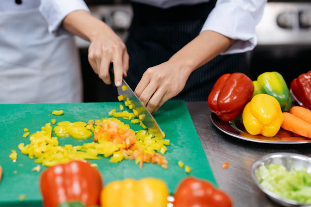 istock Chefs in uniform cutting ingredients while cooking in restaurant kitchen 2148840423