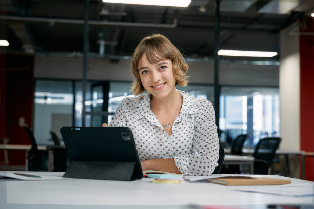 istock Happy young caucasian businesswoman smiling while using digital tablet during meeting in office 2148840478