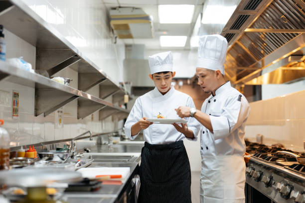 istock Male chef explains about the gourmet dish to cooking class student 2148840542