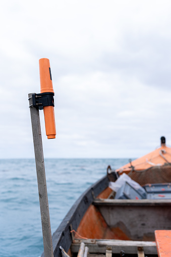 Vertical photo of a help flare on a mast of a lobster fishing boat with no people