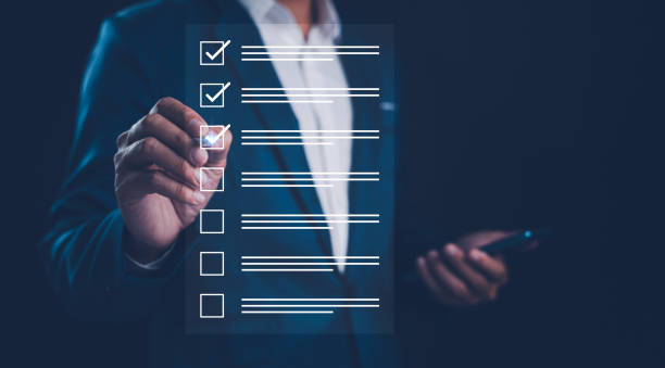 istock checklist and clipboard task management. Businessman working on laptop computer productivity checklist and filling survey form online. Document management system DMS. Assessment form, questionnaire, 2148841129