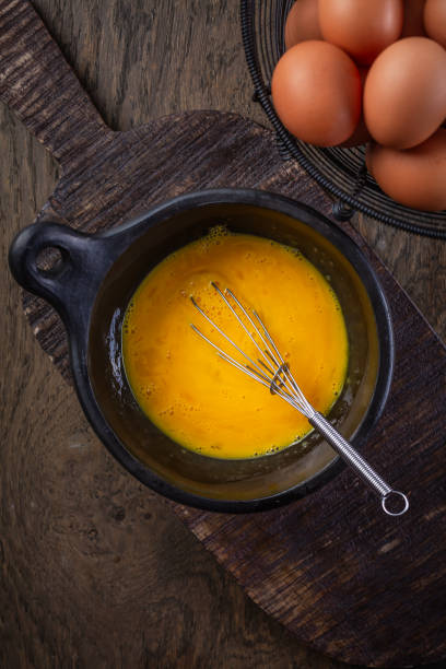 istock Organic whipped eggs in black bowl with whisk, cooking preparation 2148842685
