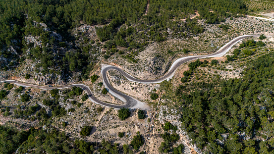 In nature with drone. View of the winding, winding road on the slope of the hill. Asphalt road.