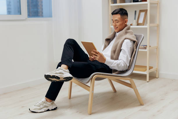 istock man with a tablet sits in a chair communication Lifestyle 2148844547