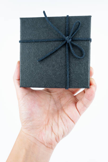 istock Hand holding black gift box on white background. 2148844571