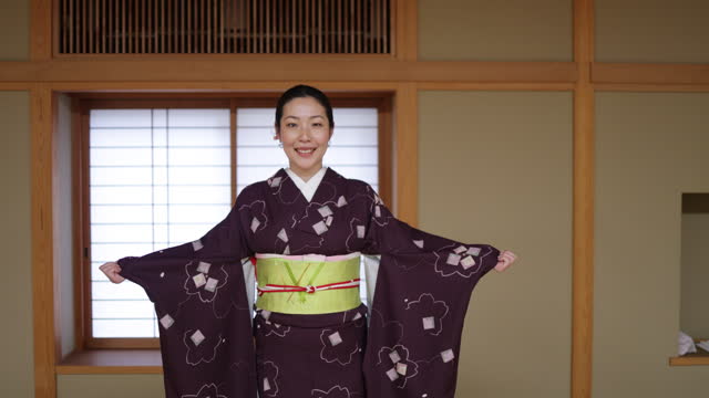 Portrait of female tourist wearing kimono in Japanese tatami room - tilt up