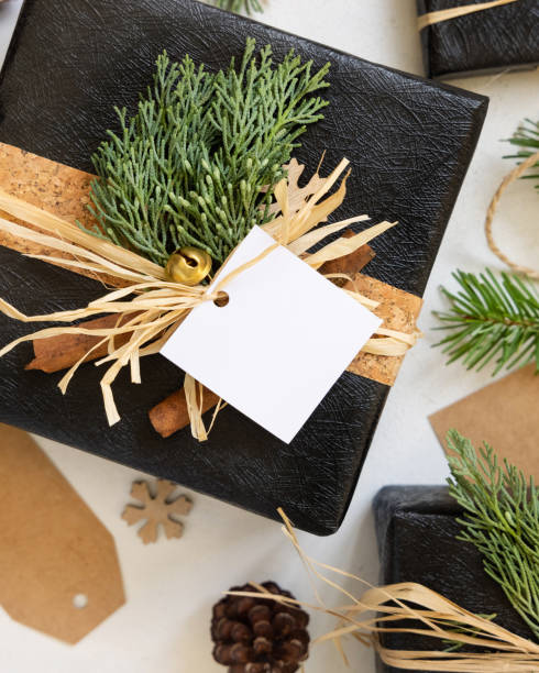 istock Black Christmas present with blank gift tag, with fir branch and decorations, Mockup 2148845175