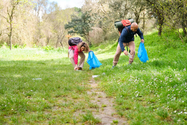 istock Two people hiking while picking up trash in nature. 2148845391