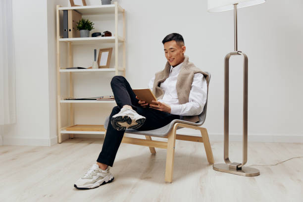 istock handsome man with a tablet sits in a chair communication interior 2148845589