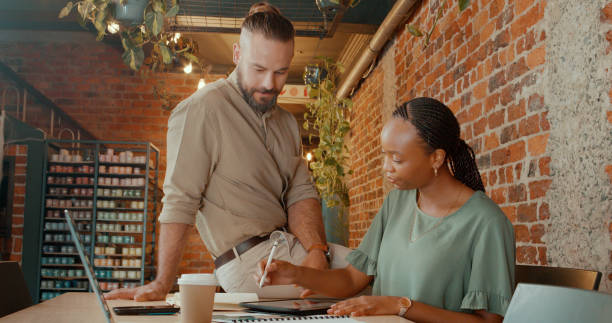istock Designers, partner and tablet in business meeting with research for creative decision making and planning. Teamwork, man or woman with solution at workplace for interior design project with writing 2148848521