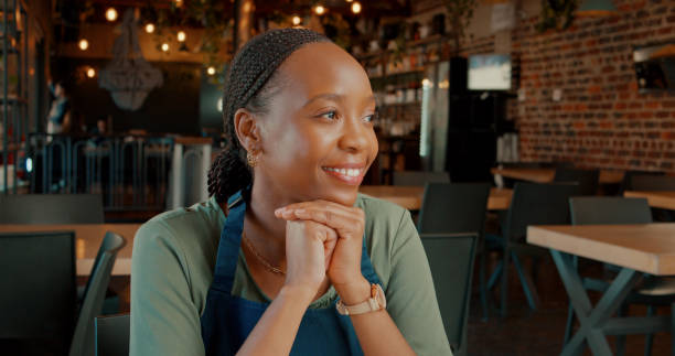 istock Thinking, happy black woman and waitress in cafe with idea, dream or problem solving in restaurant. Vision, smile and worker in coffee shop for decision, brainstorming and barista planning future 2148848685