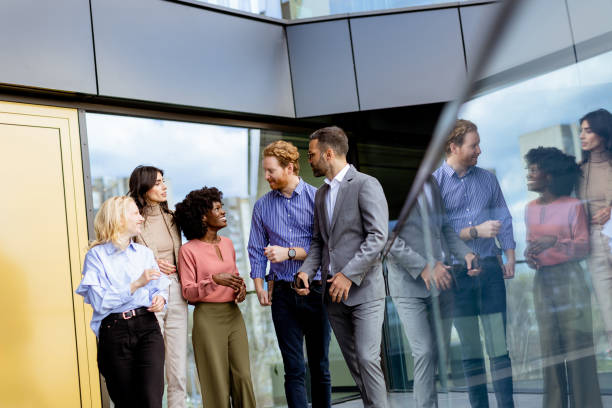 istock Diverse team of professionals discussing strategy outside modern office building at dusk 2148848802