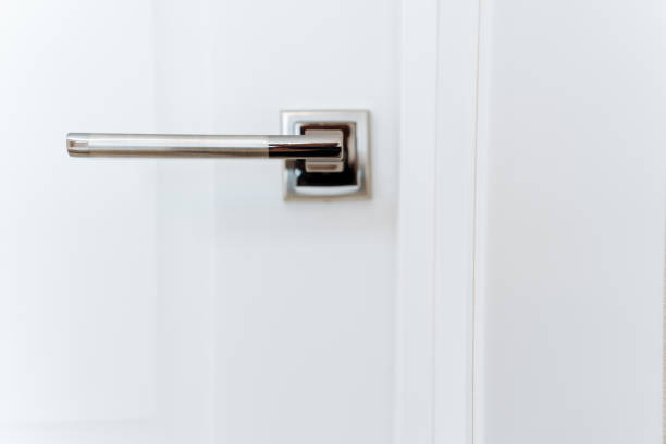 istock Shiny chrome hardware, metal handle on white door, frontal view of door handle. 2148849036